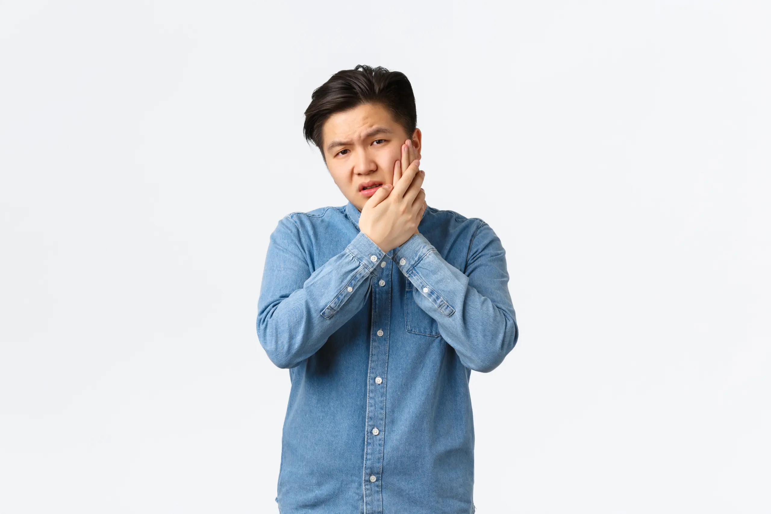 uneasy-bothered-asian-guy-complaining-painful-feeling-touching-cheek-having-toothache-need-go-stomatology-clinic-having-appointment-waiting-painkillers-standing-white-background
