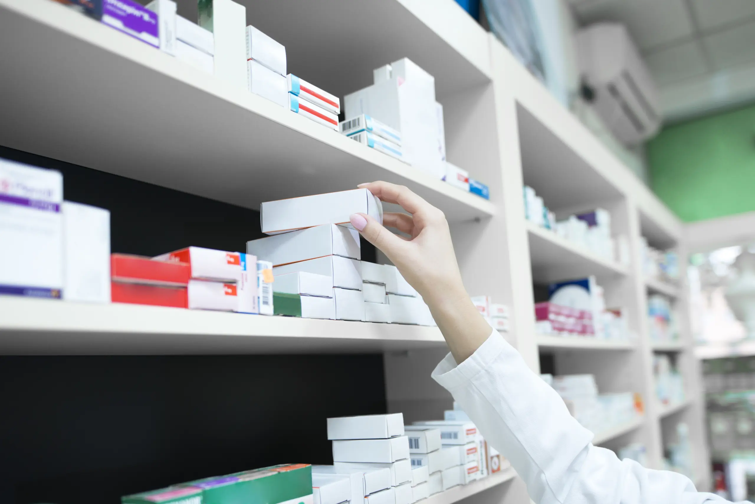 closeup-view-pharmacist-hand-taking-medicine-box-from-shelf-drug-store