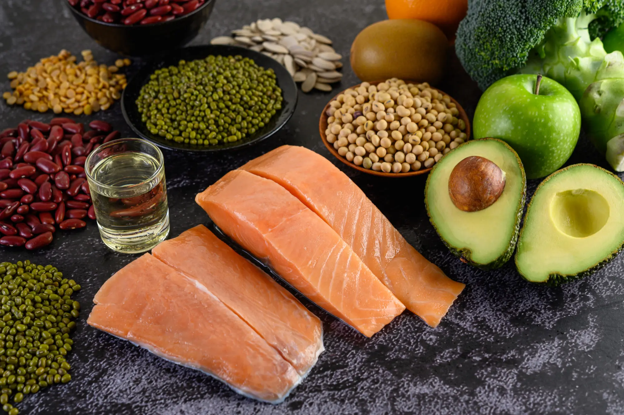 legumes-broccoli-fruit-salmon-placed-black-cement-floor