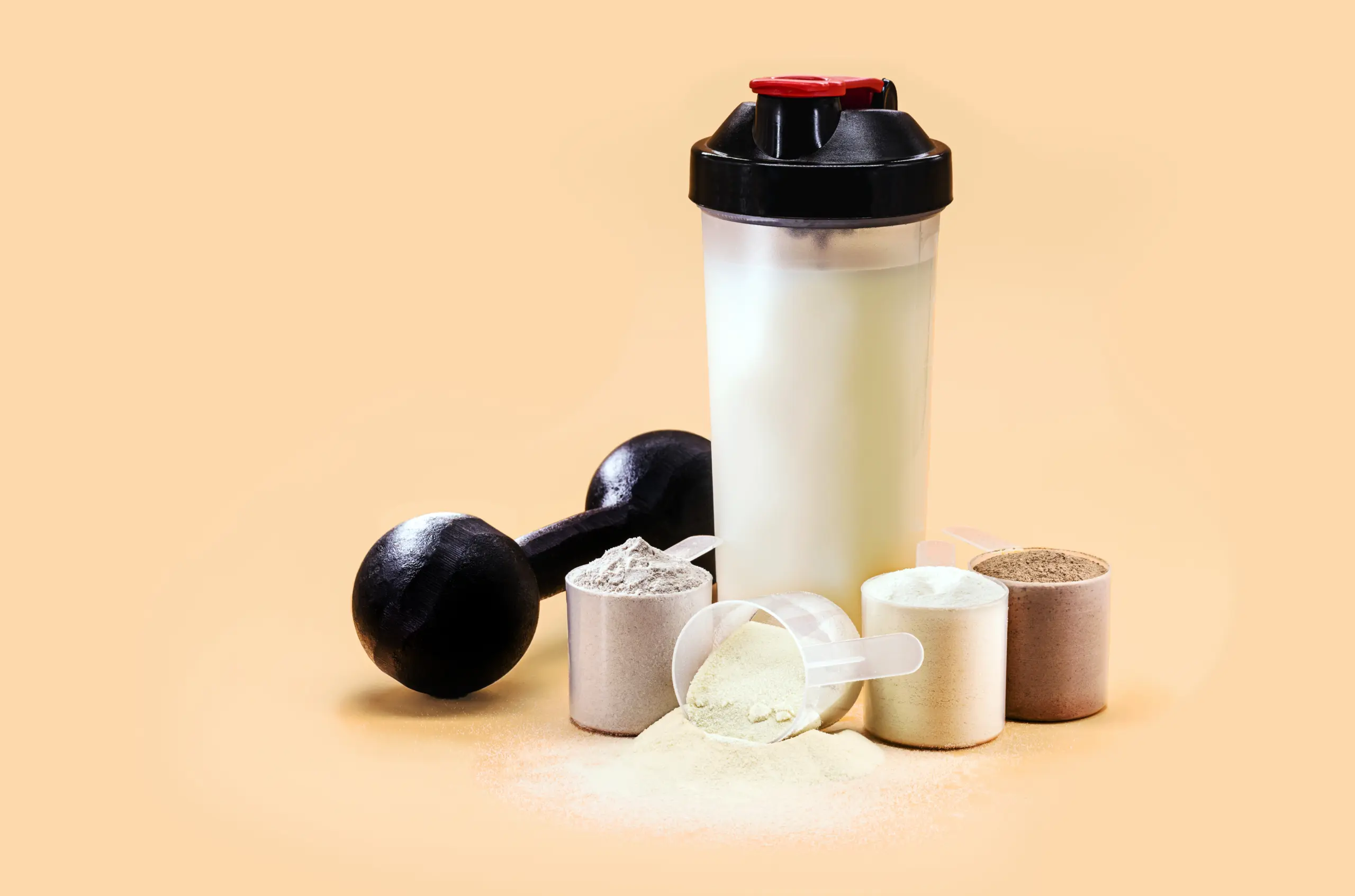 whey-casein-shake-whey-smoothie-with-protein-chocolate-bar-weight-training-dumbbell-side-creatine-blend-muscle-mass-gain-copyspace
