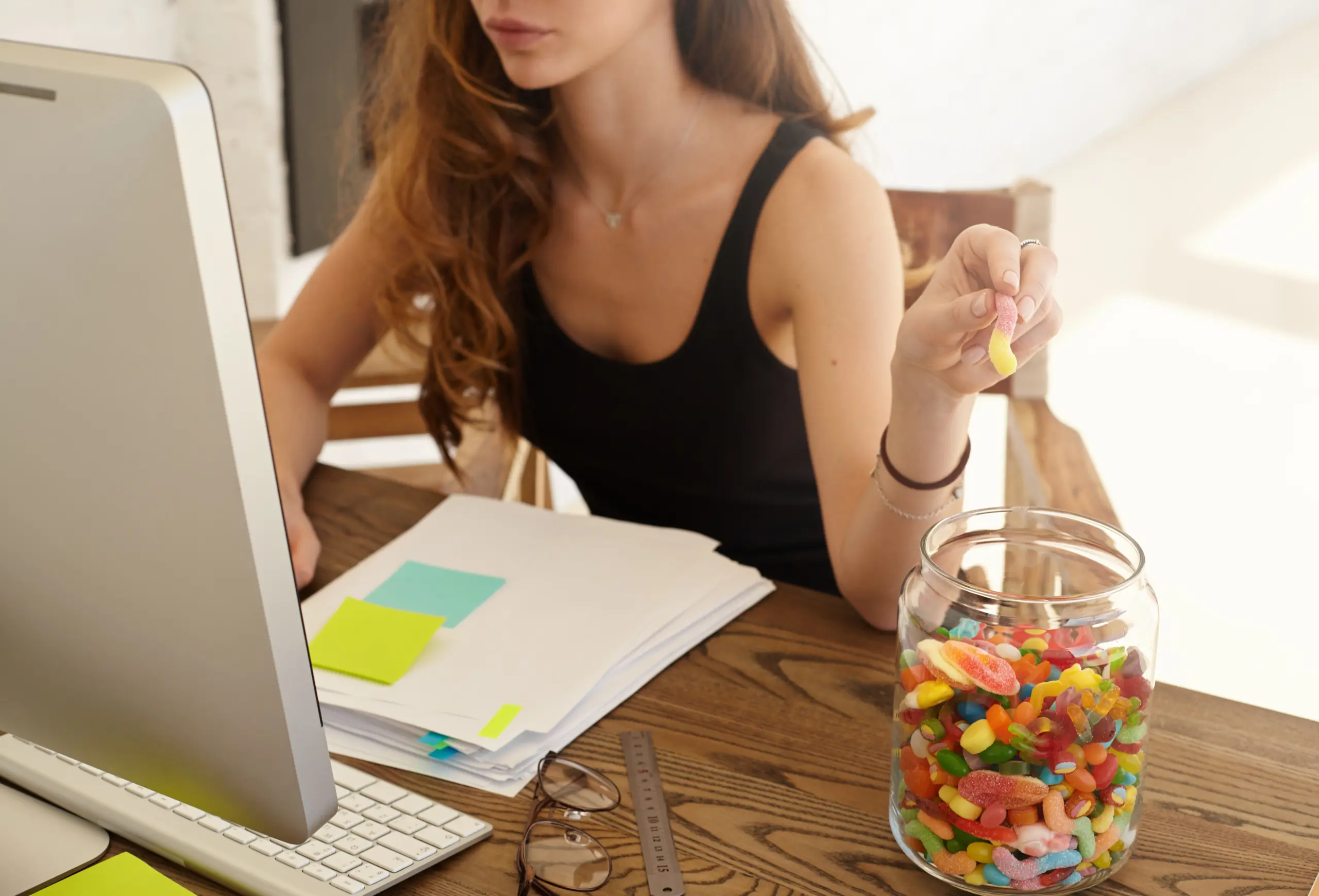 cropped-shot-caucasian-female-office-worker-taking-marmalade-from-big-jar-work-girl-eats-candies-improvement-work-brain-during-hard-work-financial-statement