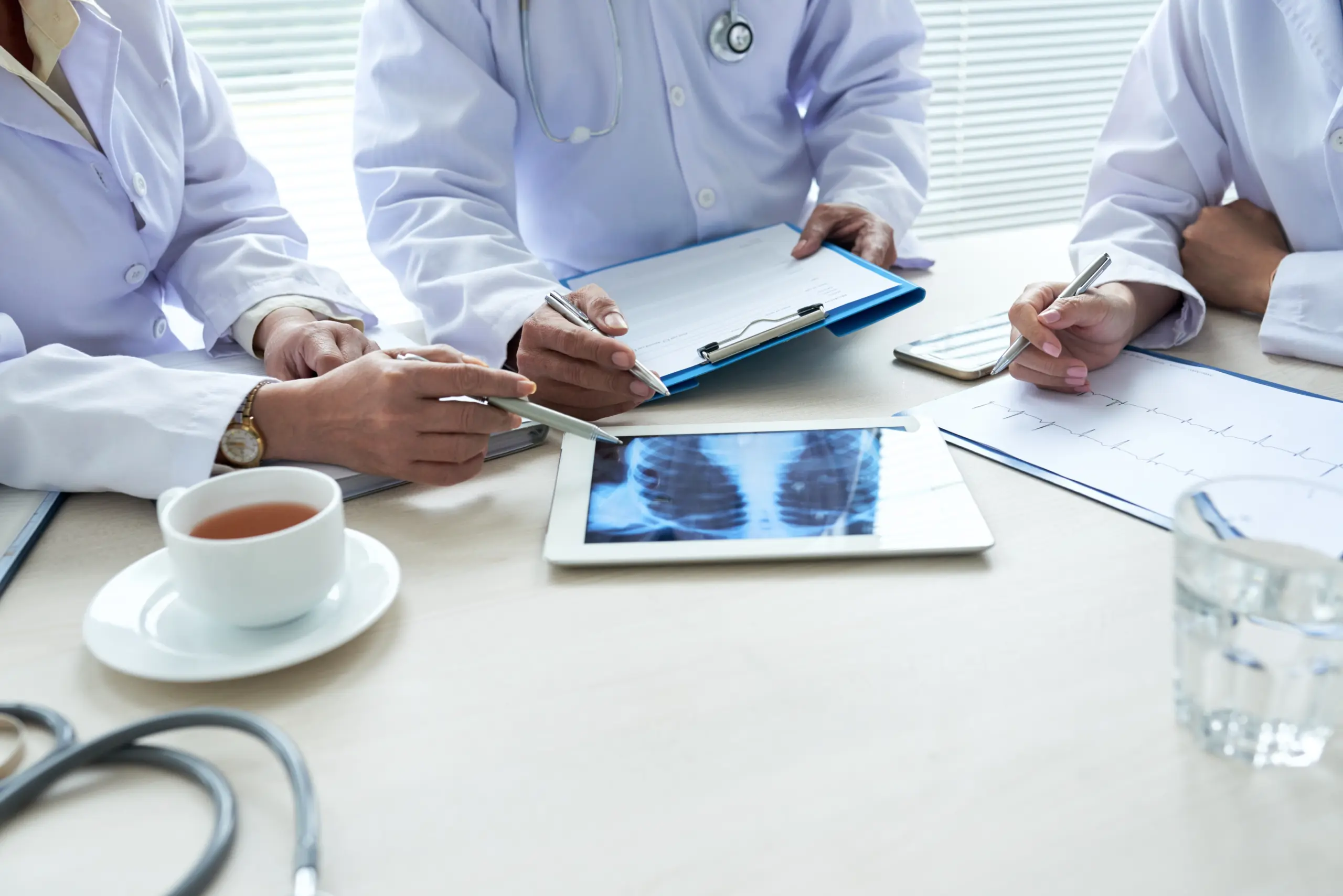 three-cropped-doctors-analyzing-chest-x-ray-digital-pad