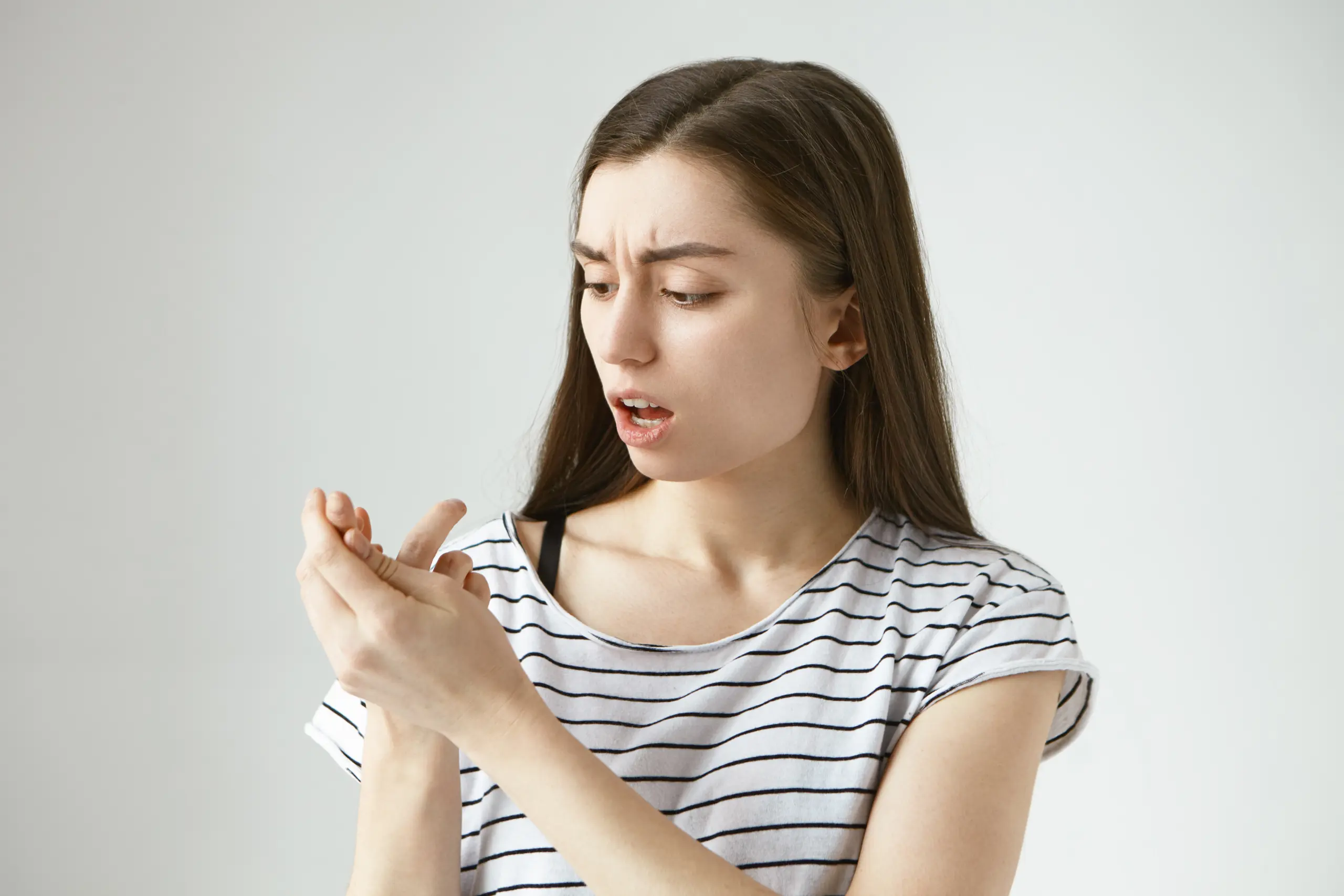 horizontal-isolated-portrait-beautiful-worried-casually-dressed-young-european-female-opening-mouth-frowning-looking-her-sprained-finger-feeling-pain-people-injury-trauma-concept