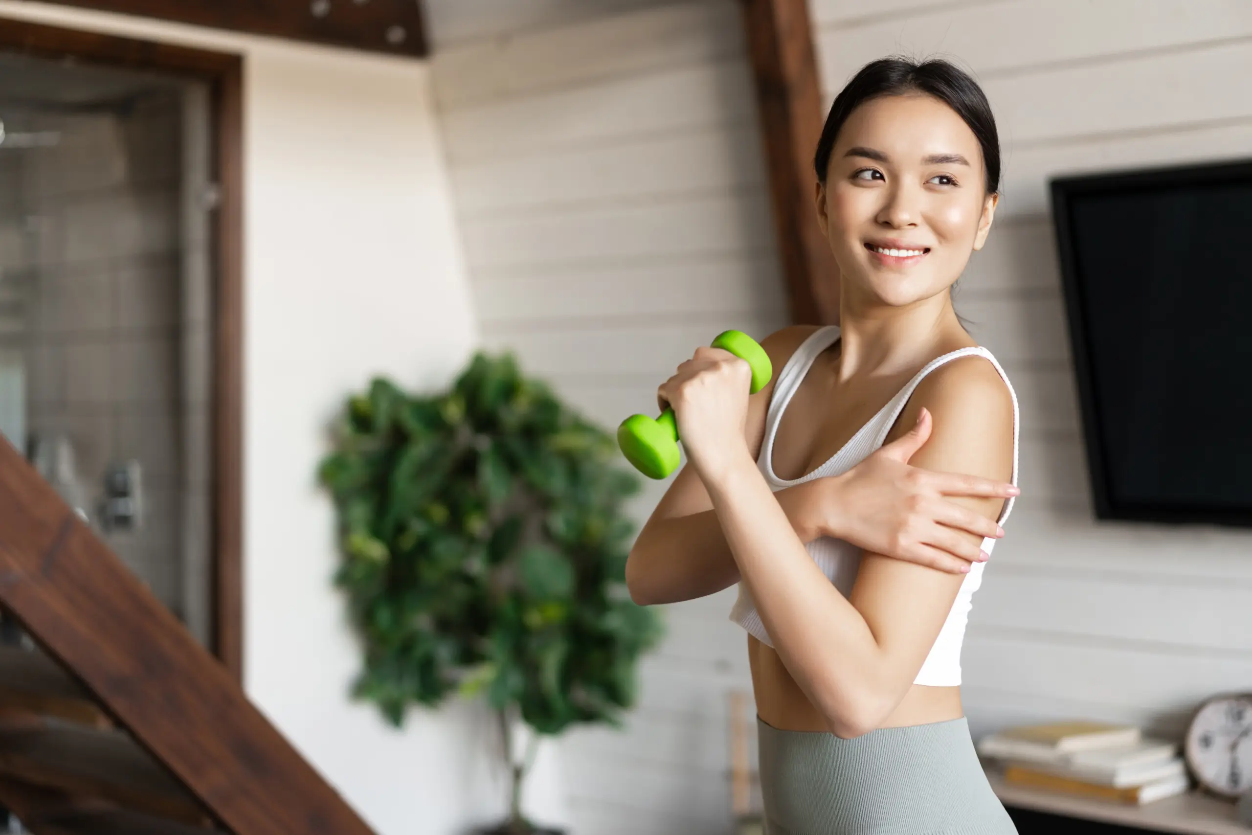 active-healthy-asian-girl-with-fit-body-doing-fitness-exercises-home-lifting-dumbbells