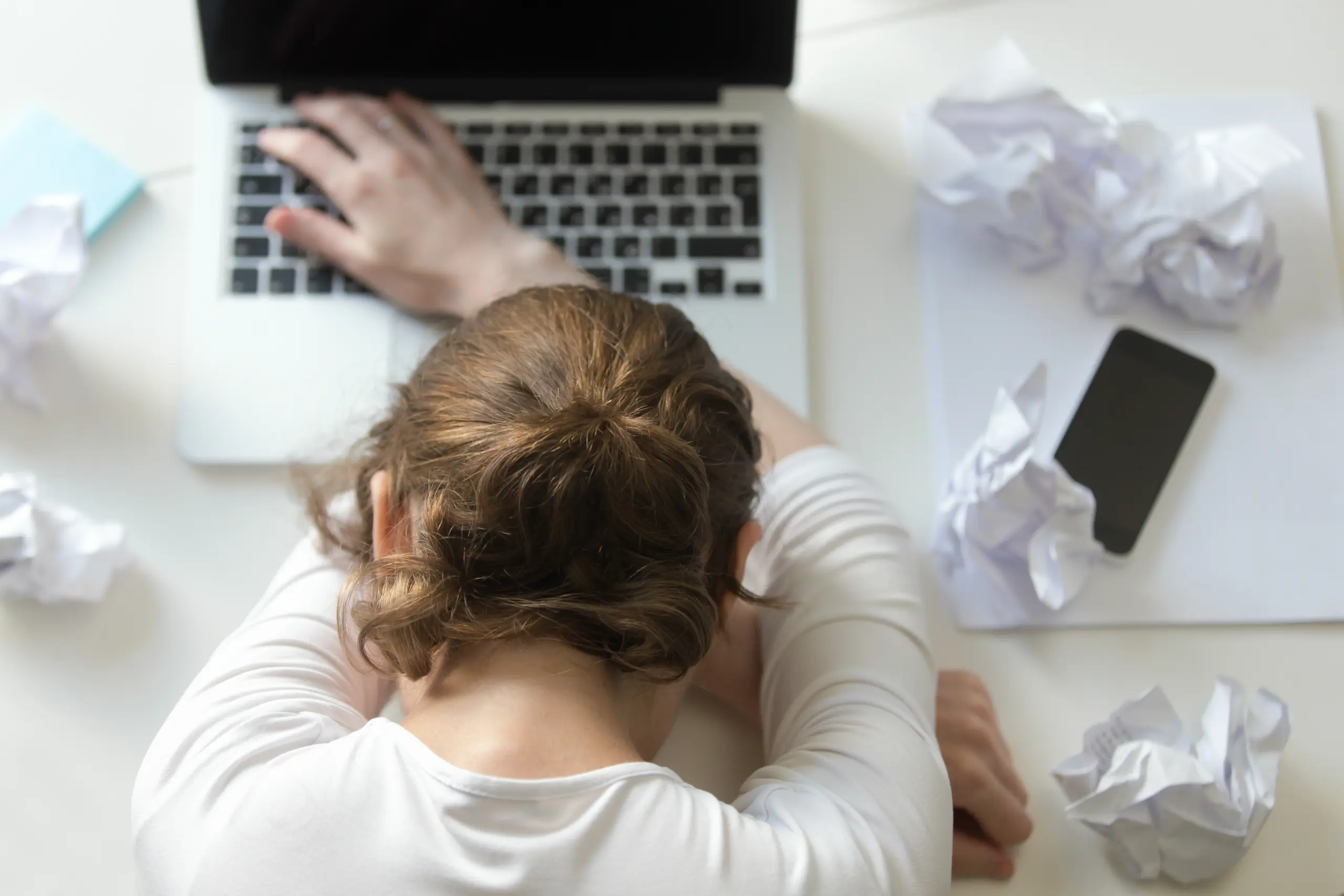 top-view-portrait-woman-lying-desk-near-laptop
