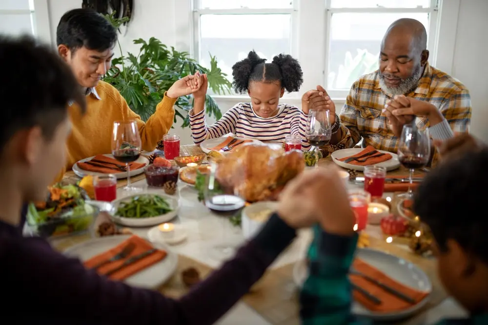 family-praying-together-before-thanksgiving-day-dinner-min